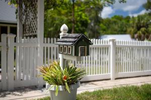 a bird house in a planter next to a fence at Noi Nest Home + Pool + Suites in Melbourne