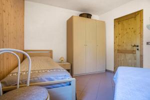 a bedroom with two beds and a cabinet in it at Casa Peio in Peio