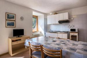 a kitchen with a table with chairs and a television at Casa Peio in Peio