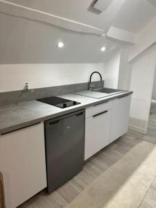 a white kitchen with a sink and a stove at appartement centre ville LILLEBONNE 2eme etage in Lillebonne