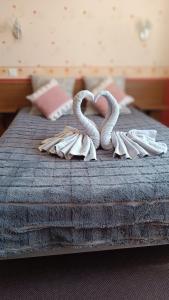 a bed with two swans made out of towels at Hôtel Le Pommeil in Guéret