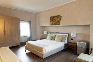 a bedroom with a large white bed and a window at Sedendo e Mirando in Neive