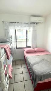 sypialnia z 2 łóżkami piętrowymi i oknem w obiekcie Casa na praia de Bombas com Piscina w mieście Bombinhas