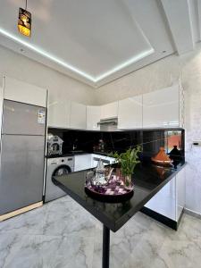 een keuken met een zwart aanrecht en een koelkast bij Villa hidaya sans vis à vis in Marrakesh