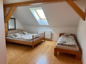 two beds in a attic bedroom with a skylight at Chalupa Chřiby in Deštné v Orlických horách