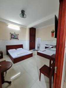 Habitación con 2 camas, mesa y TV. en Khách sạn Dạ Lan en Ðông Hòa