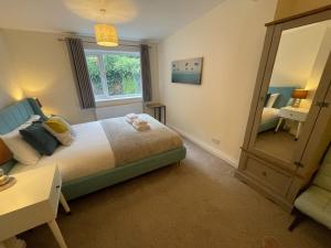een slaapkamer met een bed en een grote spiegel bij Stunning House In Beautiful Madingley Village 