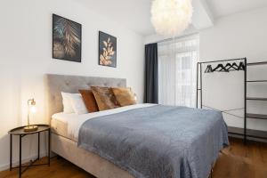 a bedroom with a large bed and a chandelier at Golden-Loft 92qm, zentral & ruhig, Messe I HBF nah in Essen