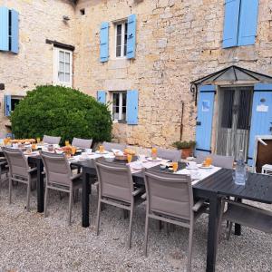 a black table and chairs in front of a building at La nouvelle vie en Quercy in Montaigu-de-Quercy