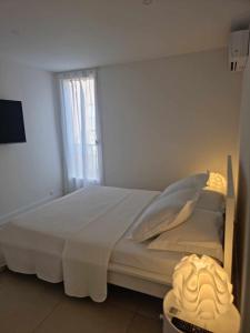 Una cama blanca en una habitación con ventana. en L ' EDEN, en Saint-Tropez 5 fotos más