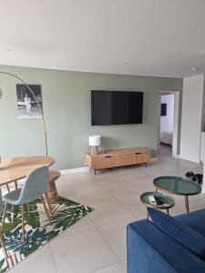 Una sala de estar con un sofá y un televisor en una pared. en L ' EDEN, en Saint-Tropez