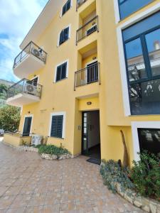 gelbes Gebäude mit Balkon und Terrasse in der Unterkunft Casalbergo Curciosrl in Belmonte Calabro