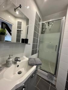 een witte badkamer met een wastafel en een douche bij Studio chaleureux hypercentre Amiens in Amiens