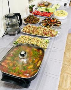 un buffet de diferentes tipos de comida en una mesa en Guest House Victor, en Zhabeshi