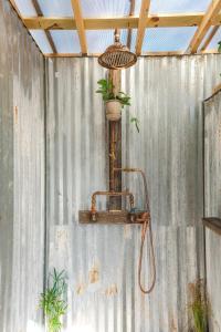 einer Metallwand mit einer Dusche mit Austenit und Licht drauf in der Unterkunft Camposanto Glamping - The Macaw Yurt in Austin