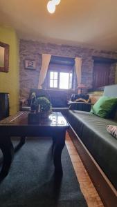 ein Wohnzimmer mit Sofa und Tisch in der Unterkunft Casa Rural Maria de Isidro in Caboalles de Arriba