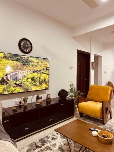 een woonkamer met een grote tv aan de muur bij Cozy Up and Relax at Oysterbay in Dar es Salaam