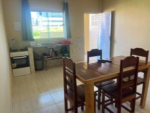 a kitchen with a wooden table and chairs in a kitchen at Residencial Negroni in Salinópolis