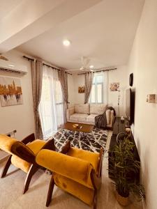 een woonkamer met gele stoelen en een bank bij Cozy Up and Relax at Oysterbay in Dar es Salaam