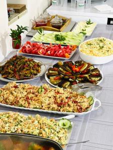 un buffet con molti tipi di cibo diversi su un tavolo di Guest House Victor a Zhabeshi