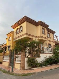 une maison jaune avec une clôture devant elle dans l'établissement Villa Miriam, à Padul
