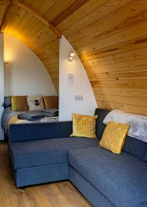 a room with two beds and a couch with pillows at Malhamdale Glamping in Skipton