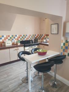 a kitchen with a table and two bar stools at The Villa Farmhouse in Cushendun