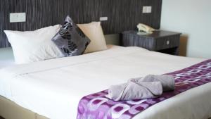 a bedroom with a bed with white sheets and pillows at Salsa Resort Langkawi By Casa Loma in Pantai Cenang