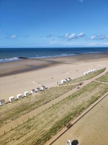 an aerial view of a beach with umbrellas and the ocean at LUXURY APP, frontal sea View + south terrace + garage in Middelkerke