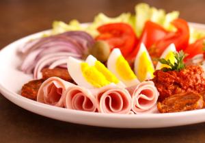 un plato de comida con carne y verduras en una mesa en Villa Stipino, en Čeminac
