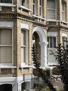 un bâtiment en briques avec une fenêtre cintrée et une clôture dans l'établissement Stunning Victorian Mansion Flat, à Brighton et Hove