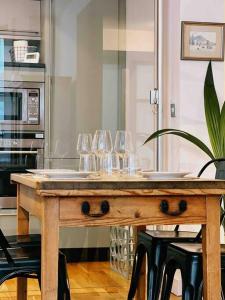 a wooden table with wine glasses on it in a kitchen at Stunning Victorian Mansion Flat in Brighton & Hove