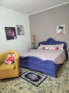 um quarto com uma cama azul e uma cadeira em Casa vacanza da Giuseppe em Leonforte