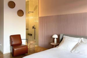 - une chambre avec un lit, une chaise et une douche dans l'établissement Luxury Apartment, Bathtub view to the Main Square, à Cluj-Napoca