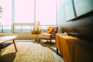 un soggiorno con TV, sedia e finestra di NEW Luxury 2BR Penthouse Apt In Central Halifax a Halifax