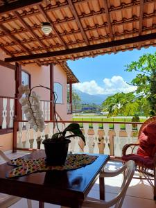 a table with a potted plant on a balcony at Casa do Éden in Paraty