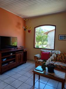 a living room with a couch and a tv at Casa do Éden in Paraty