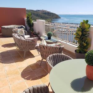 a patio with chairs and tables and a view of the ocean at Boricua Realty VIP Luxury Ocean Front Penthouse 3 Bedrooms 3 Bathrooms 2 Levels in Fajardo