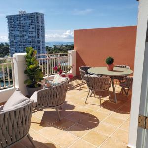 d'une terrasse avec une table et des chaises sur un balcon. dans l'établissement Boricua Realty VIP Luxury Ocean Front Penthouse 3 Bedrooms 3 Bathrooms 2 Levels, à Fajardo