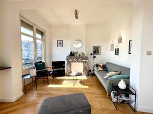 een woonkamer met een bank en een open haard bij Bellevue - Sur les quais de la Meuse in Luik