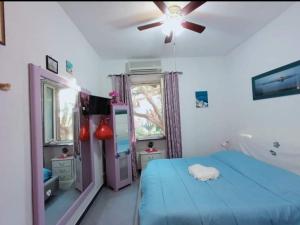 sypialnia z niebieskim łóżkiem i wentylatorem sufitowym w obiekcie Casa Sonia w mieście Ischia