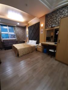 ein großes Schlafzimmer mit einem Bett und einem Schreibtisch in der Unterkunft Xinghe Motel - Chaozhou in Chaozhou