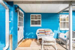 a blue house with a porch with wicker chairs at In the Center of Gulfport, Min Away From the Beach! in St Petersburg +25 photos