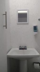 a white bathroom with a sink and a mirror at Q'entiHospedaje San Blas 1 in Cusco