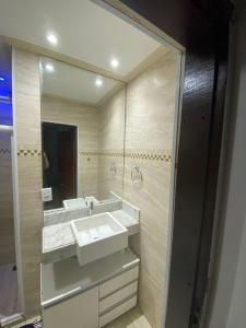 a bathroom with a sink and a large mirror at Casa do Mar Stella Maris in Salvador