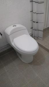a white toilet sitting in a bathroom at Q'entiHospedaje San Blas 1 in Cusco