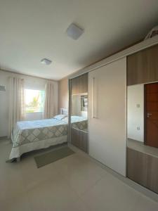1 dormitorio con 1 cama y puerta corredera de cristal en Casa do Mar Stella Maris, en Salvador