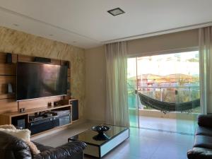 uma sala de estar com um sofá e uma televisão em Casa do Mar Stella Maris em Salvador