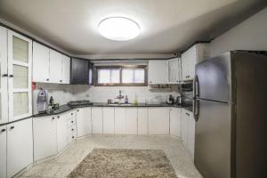 a kitchen with white cabinets and a stainless steel refrigerator at אתנחתא בכנרת in Tiberias
