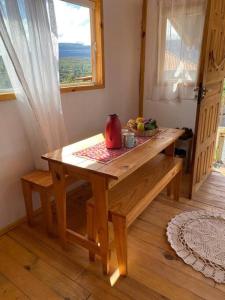 a wooden table in a room with a window at Chalé Vida Boa: Paz e Aconchego in Vale do Capao